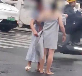 洛阳女子赤裸全身站在街头,路人围观拍照,好心人为她裹上围巾